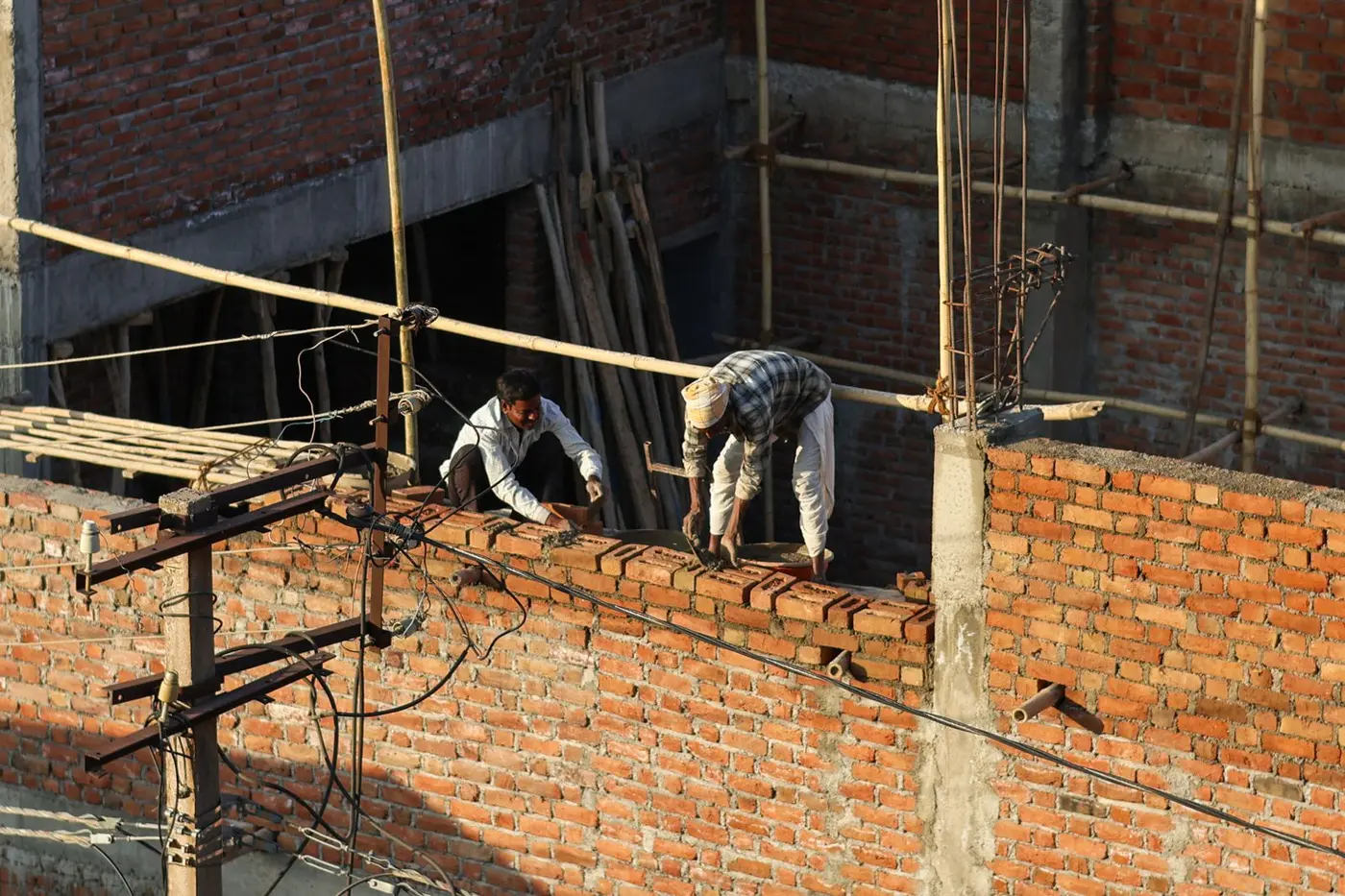 Bricklayers working on a construction site laying brickwork by hand