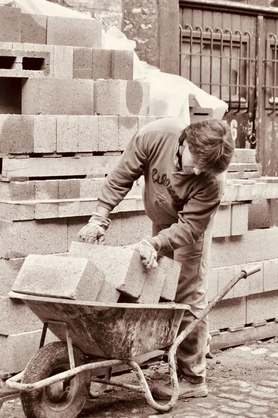A worker moving a load of bricks on a wheelbarrow
