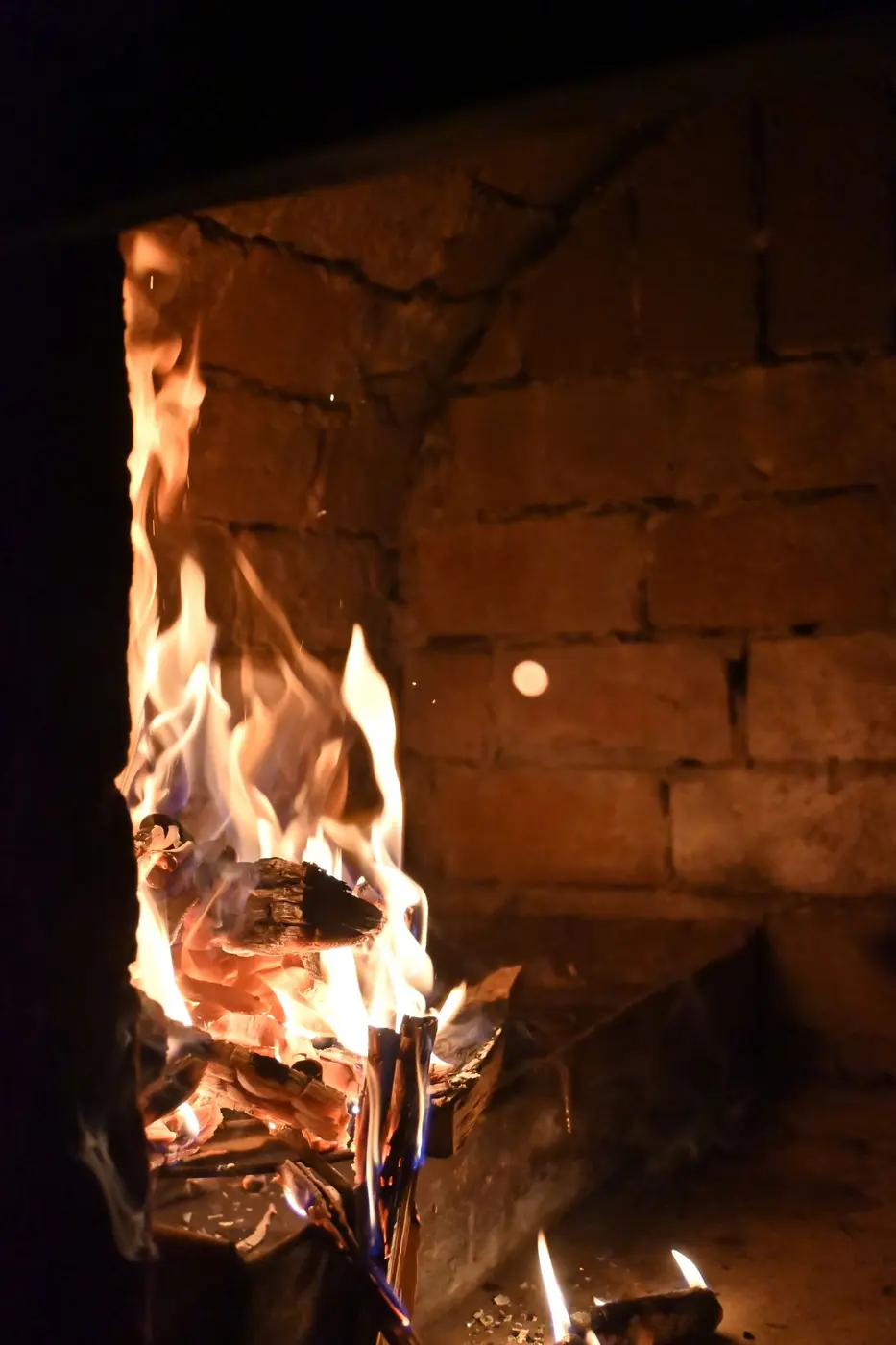 The warm glow of flames held inside a rustic brick oven