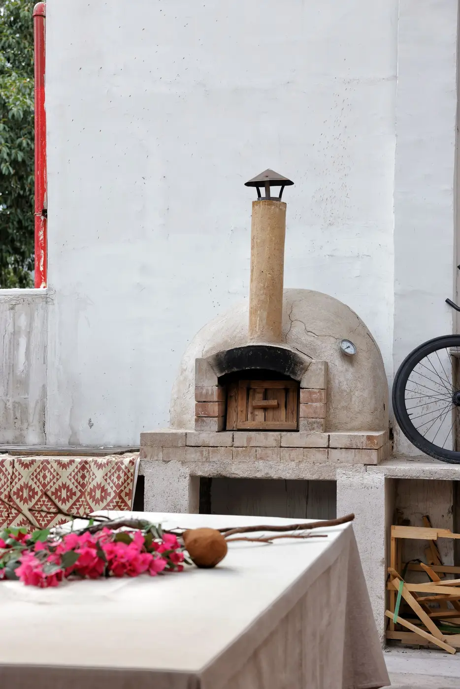 A finished rendered wood-fired pizza oven standing outdoors