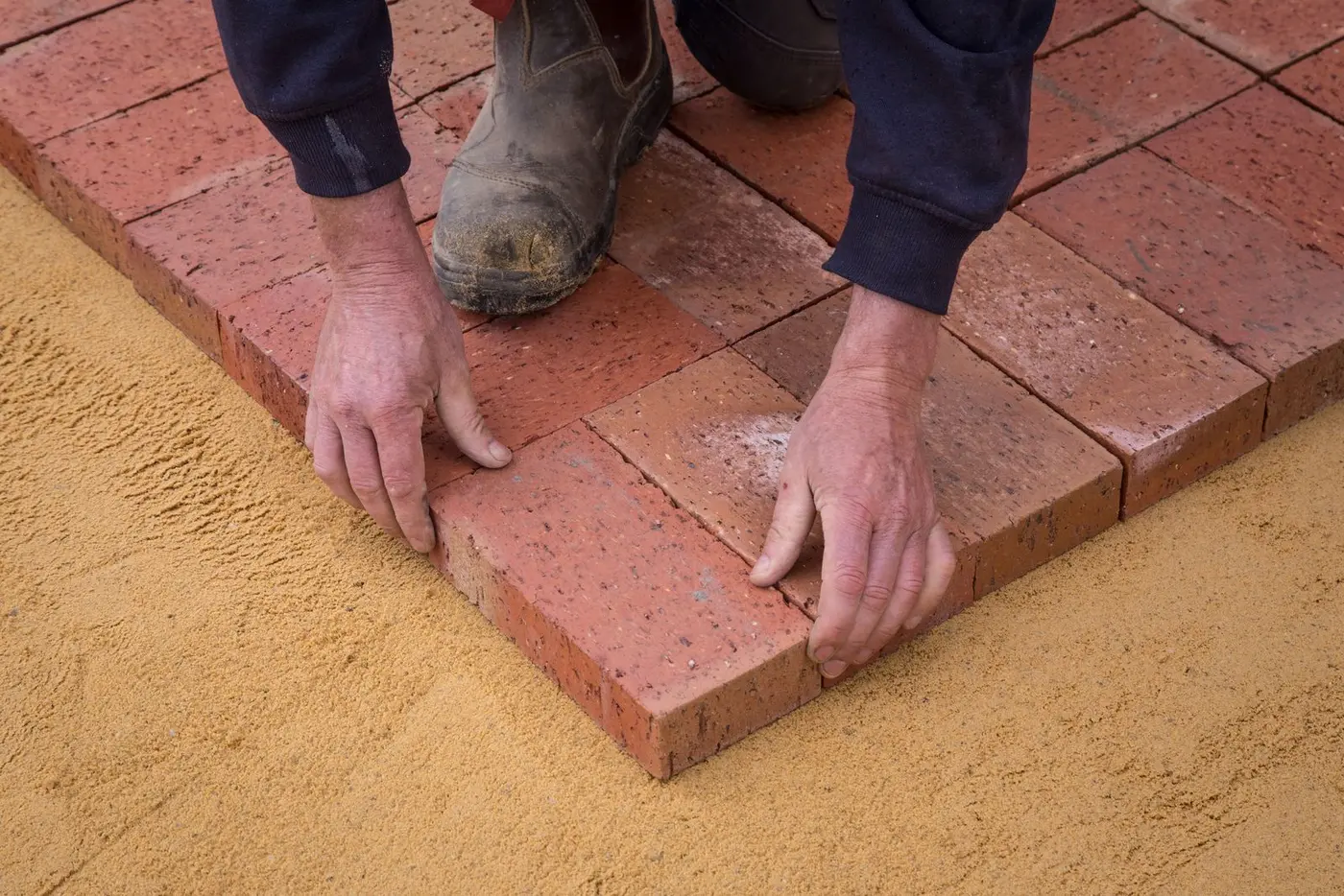 A builder laying brickwork by hand on a construction site