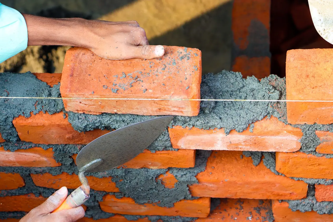 Close-up of a mason building a brick wall