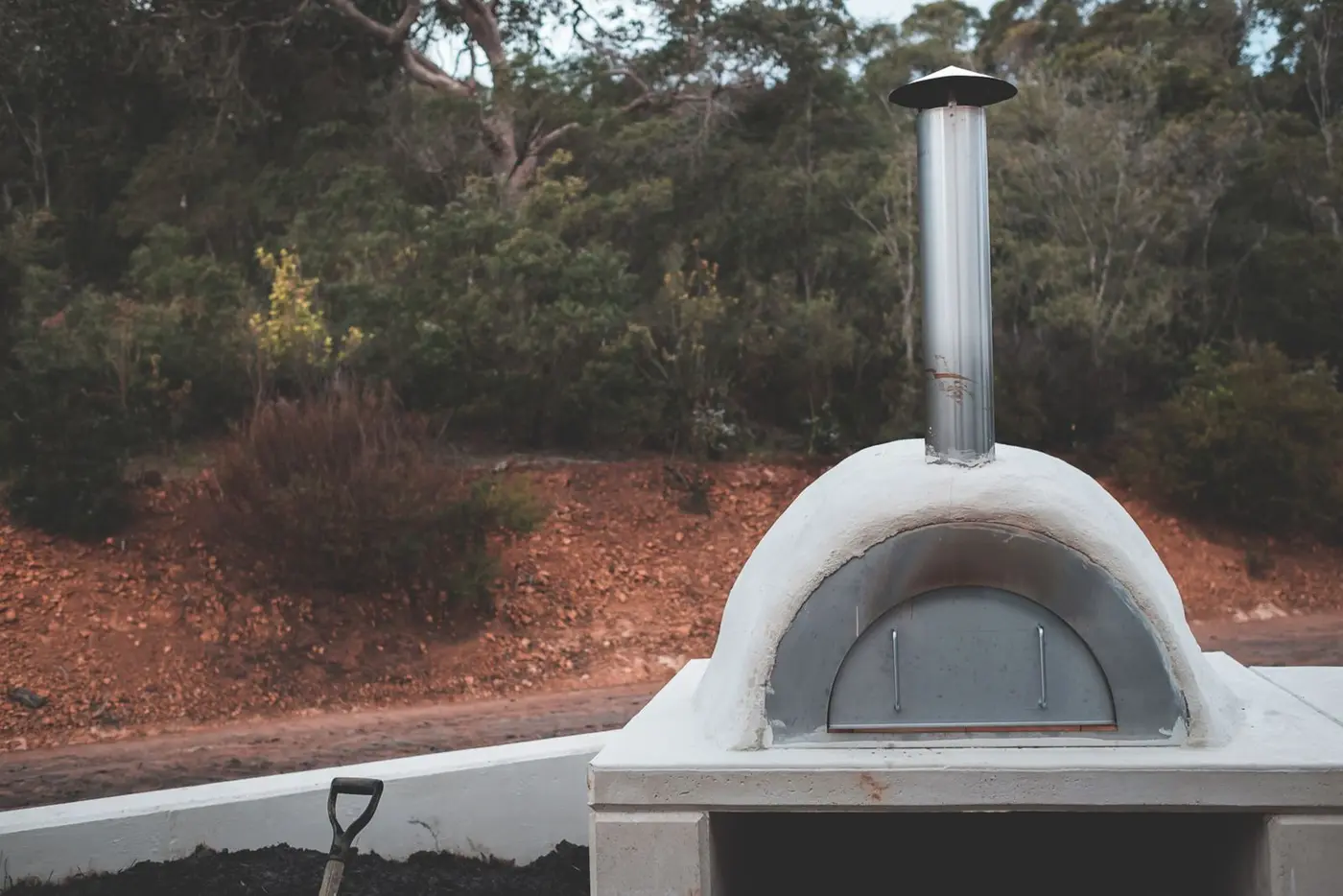A stone oven with its flue and chimney visible outdoors