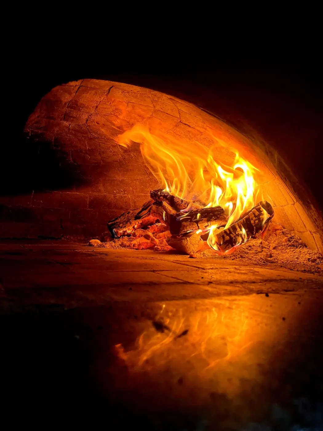 Flames glowing inside the dome of a wood-fired oven